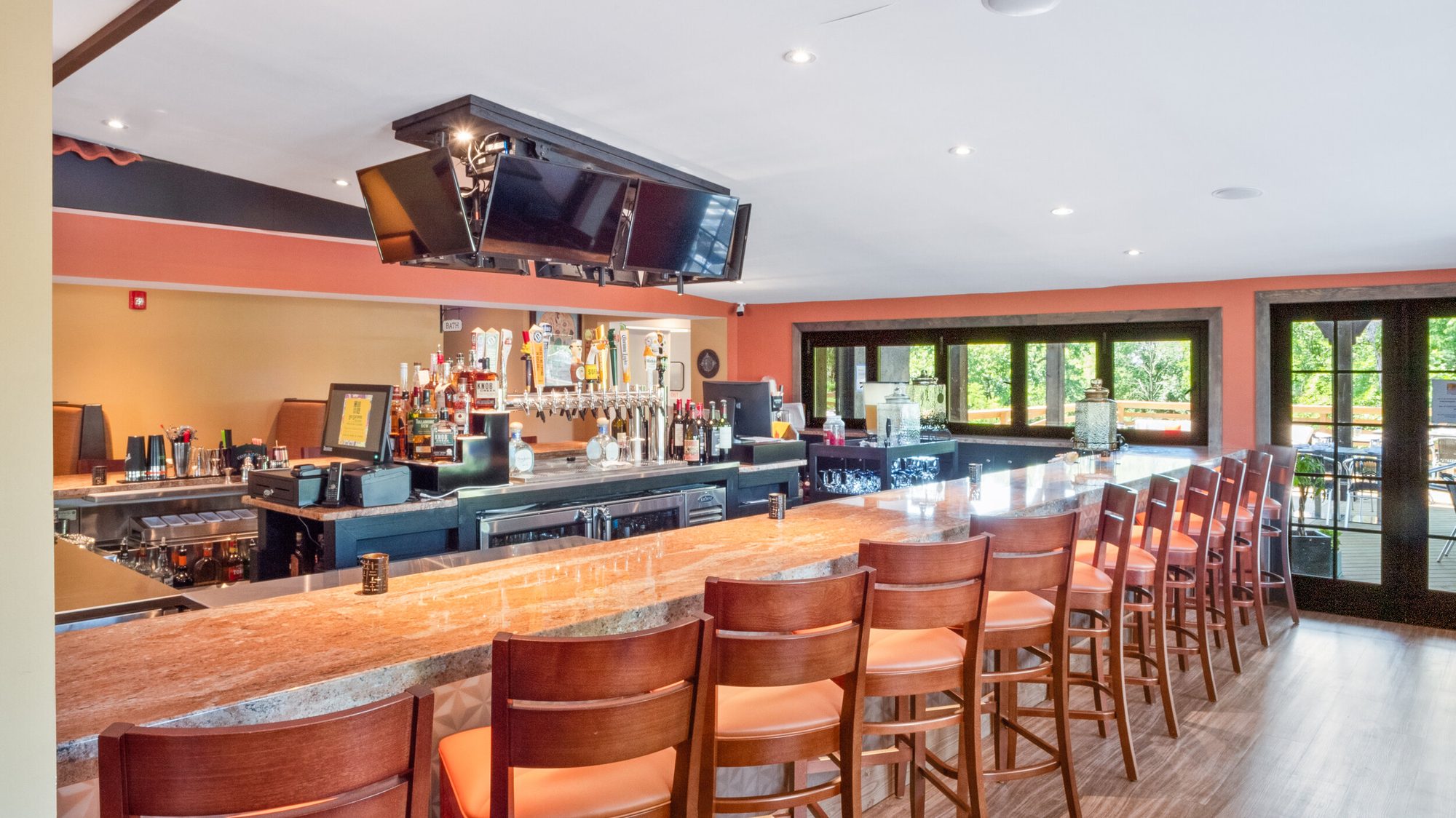 The full length of the bar, stools down one side