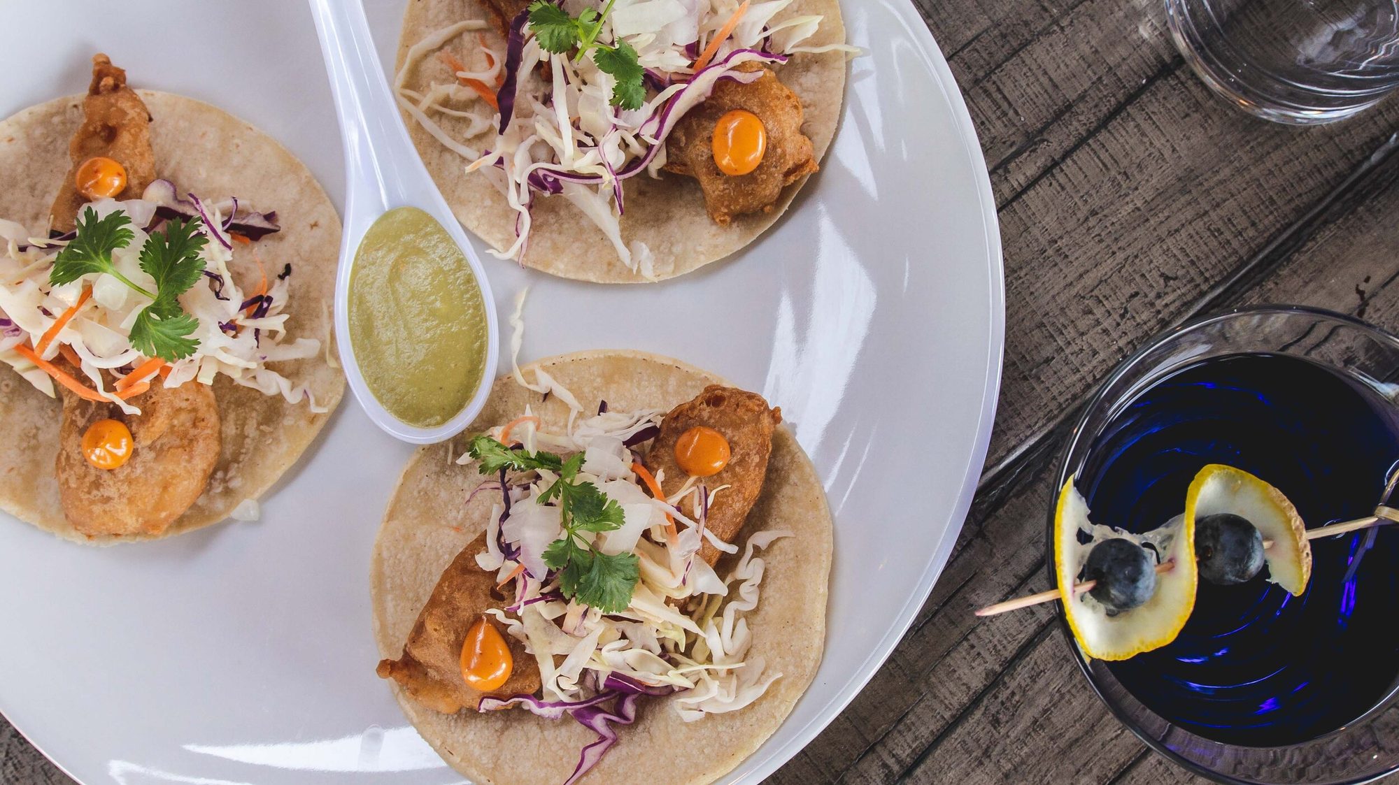 Three fish tacos with slaw and a green salsa