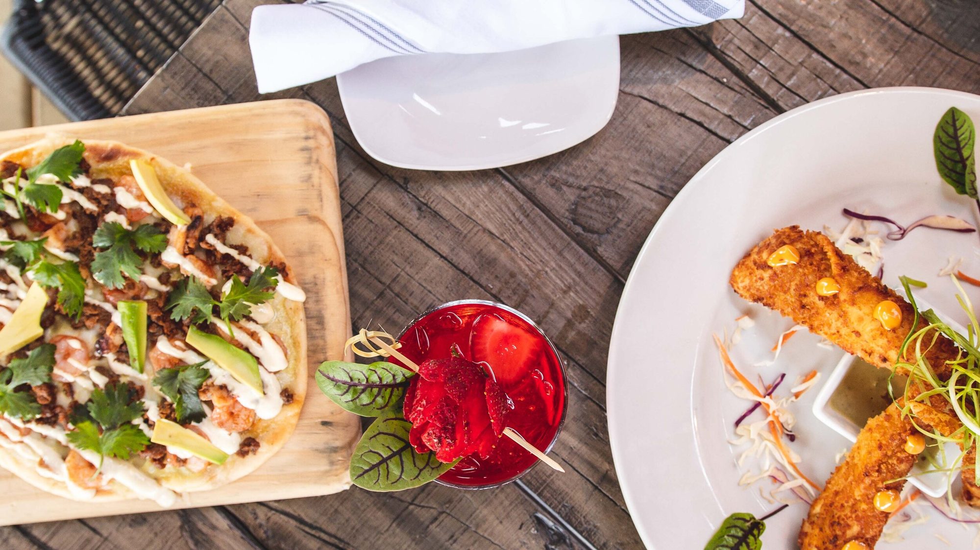 A flatbread and a cocktail together on the table