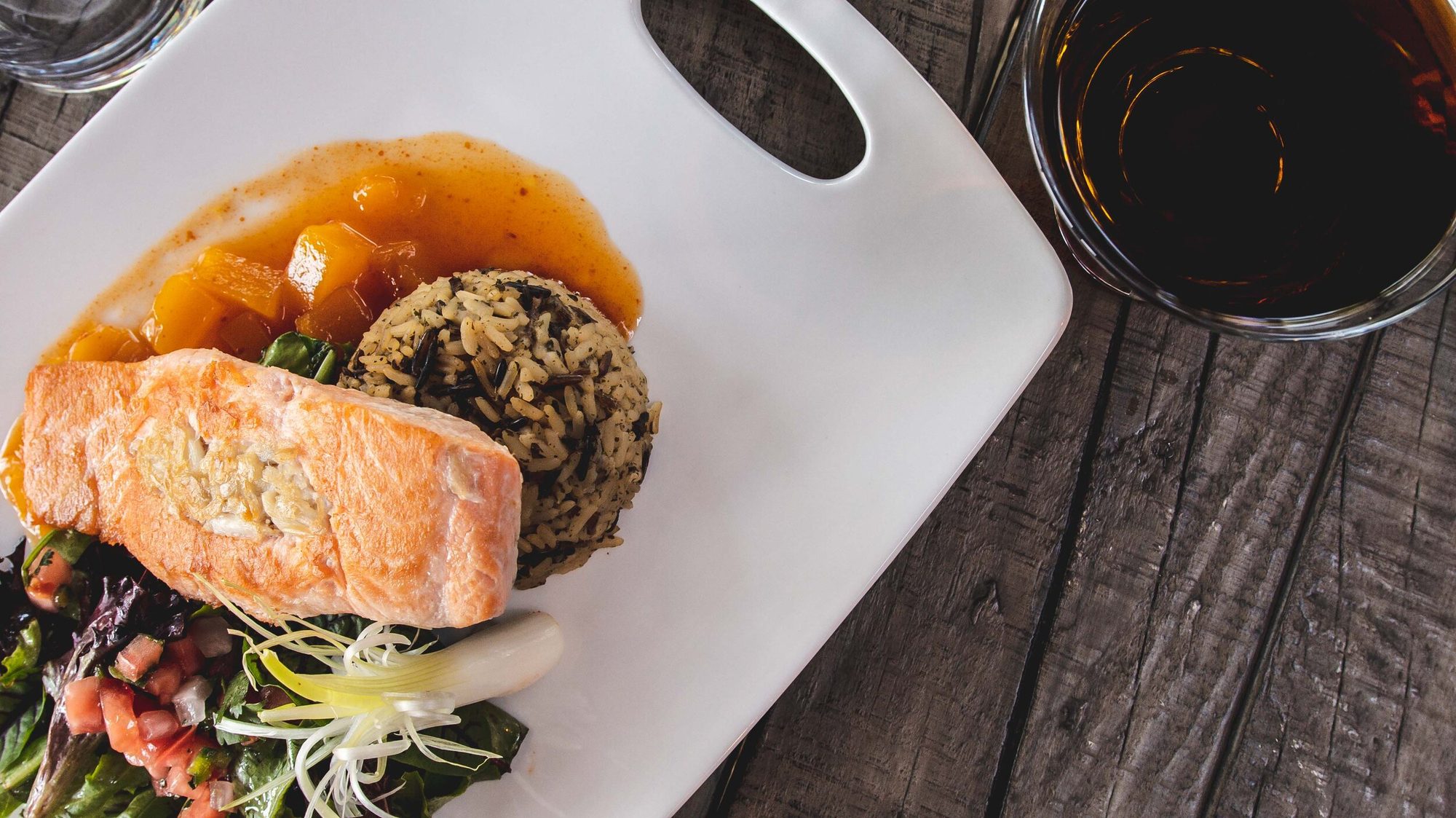 Salmon plated with rice, a drink alongside