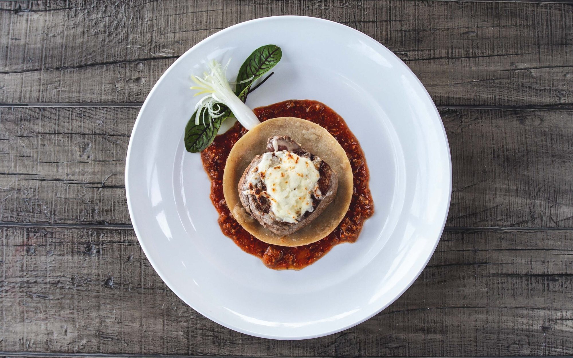 A beef medallion in red sauce, seen from above