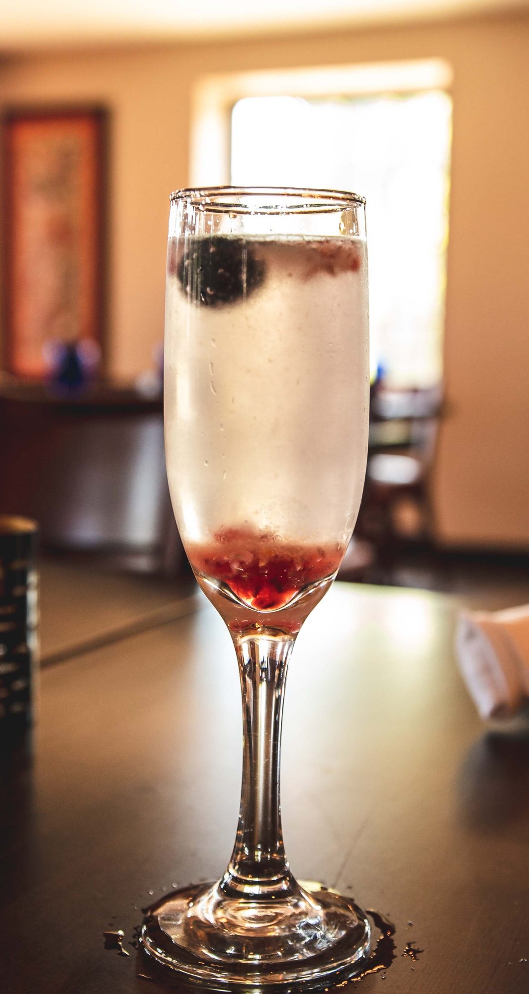 A sparkling flute with a berry dropped in