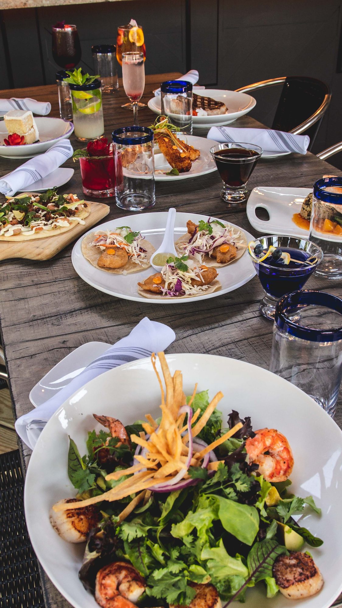 Dishes and glasses set out down the table